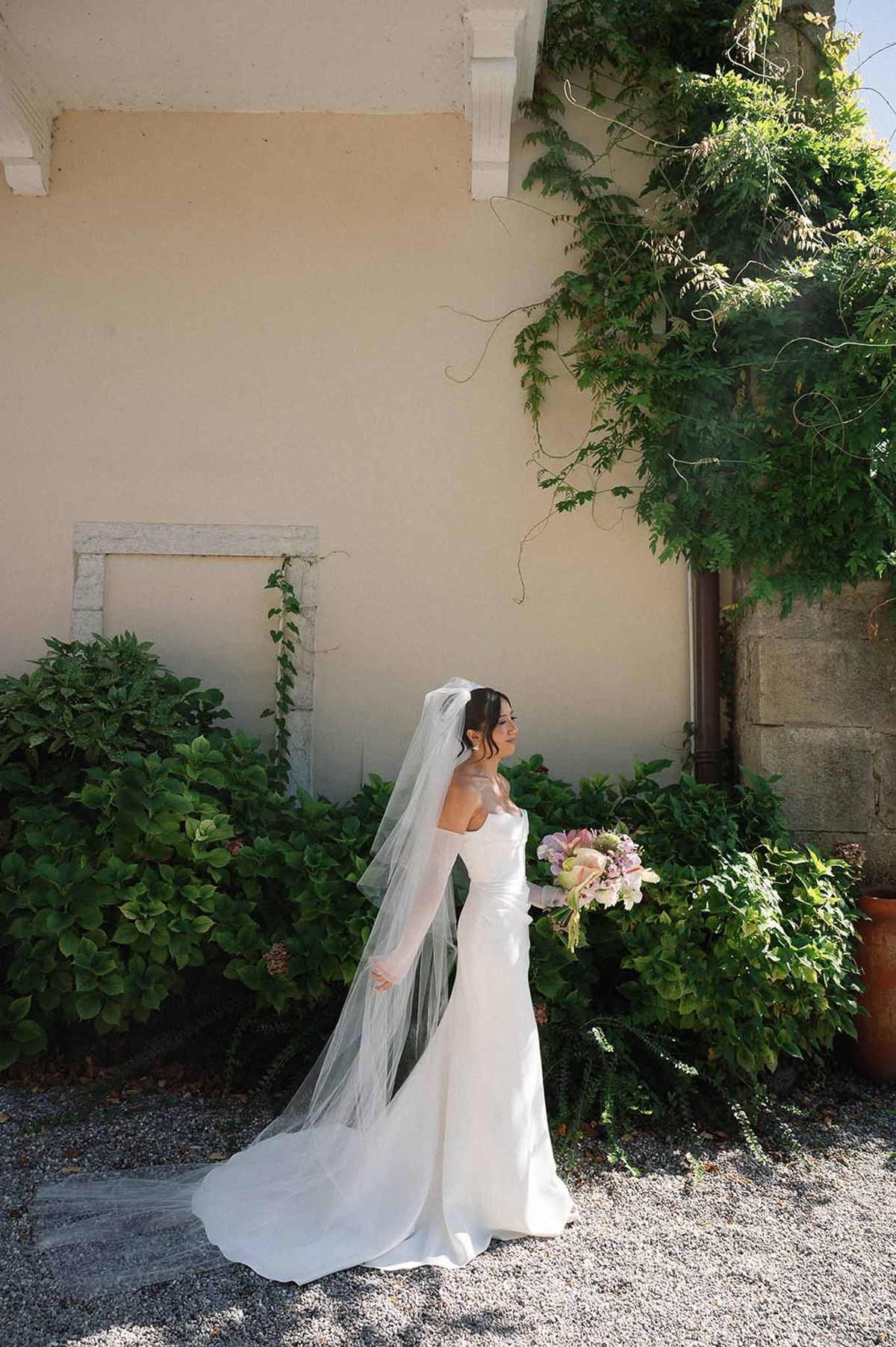 Bride in mermaid gown with cathedral veil in abbey garden at Abbaye de Talloires