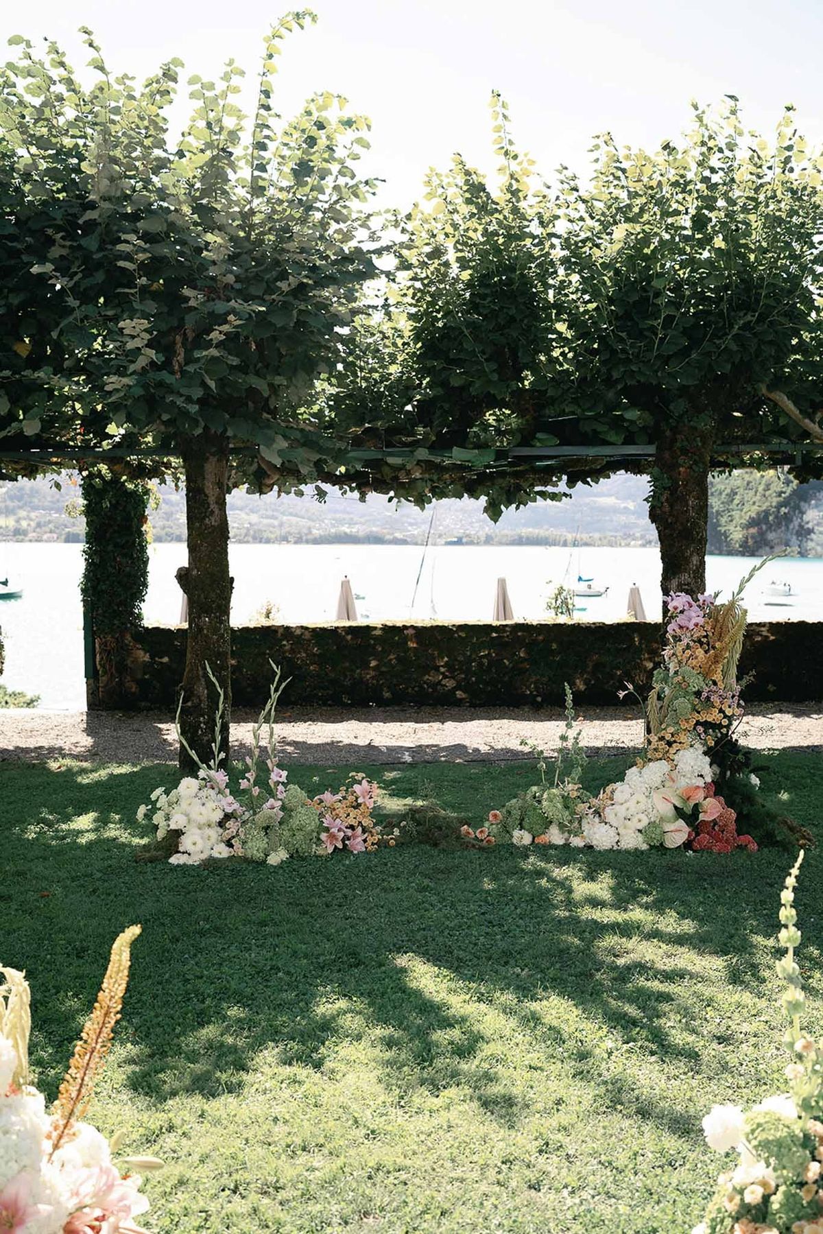Pleached tree ceremony altar with wild florals and lake view at Abbaye de Talloires