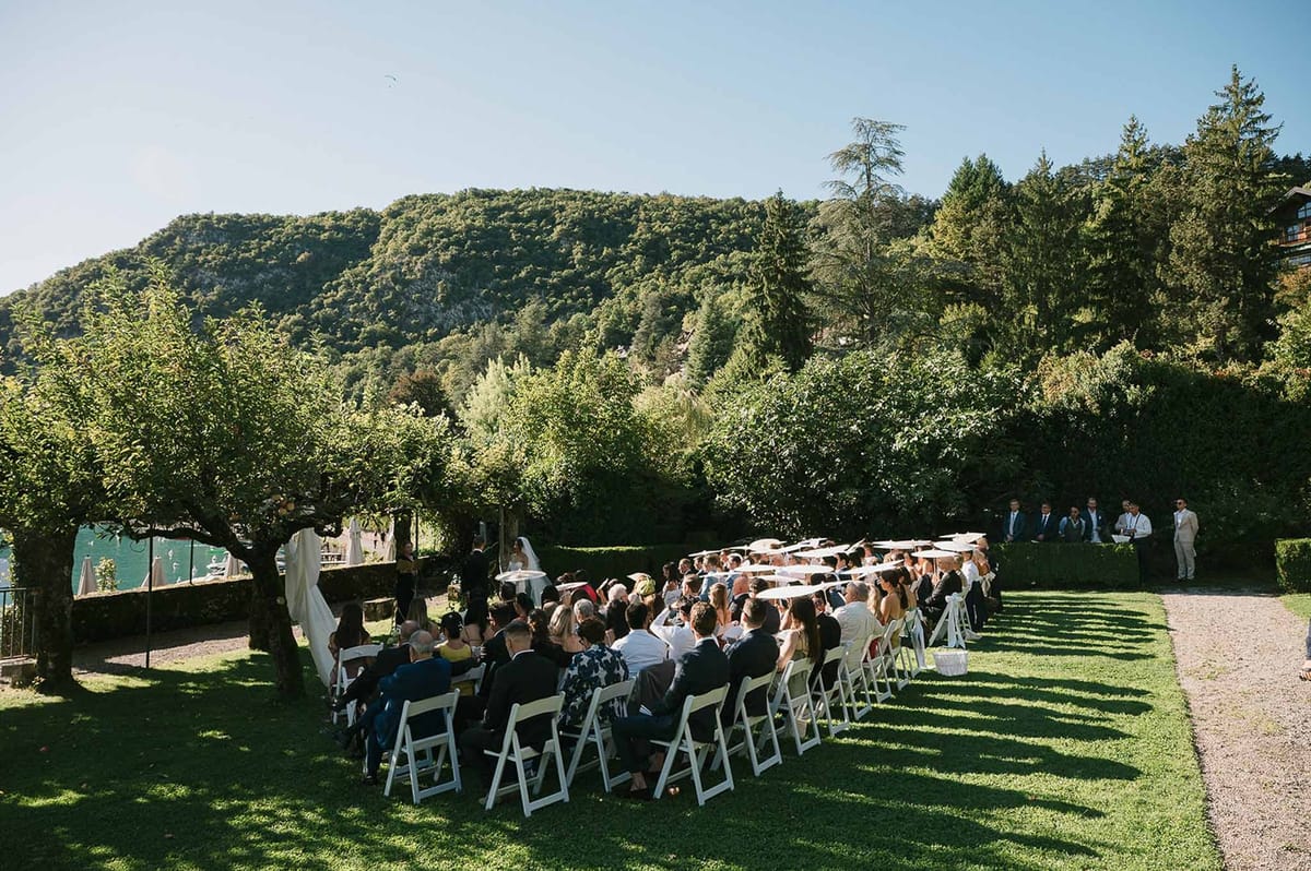 Ceremony guests on lawn with Alpine mountain behind at Abbaye de Talloires