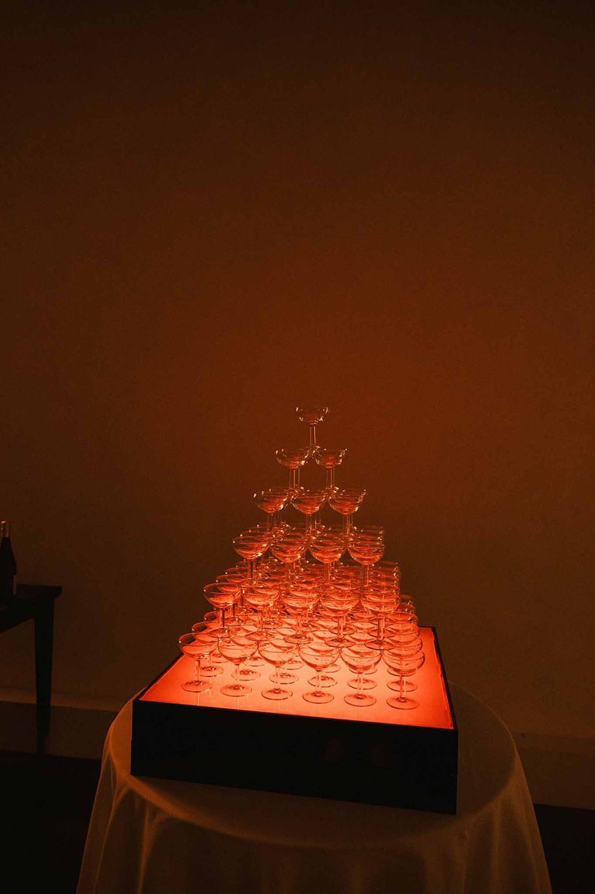 Champagne tower with red floral arrangements on reception table at Abbaye de Talloires
