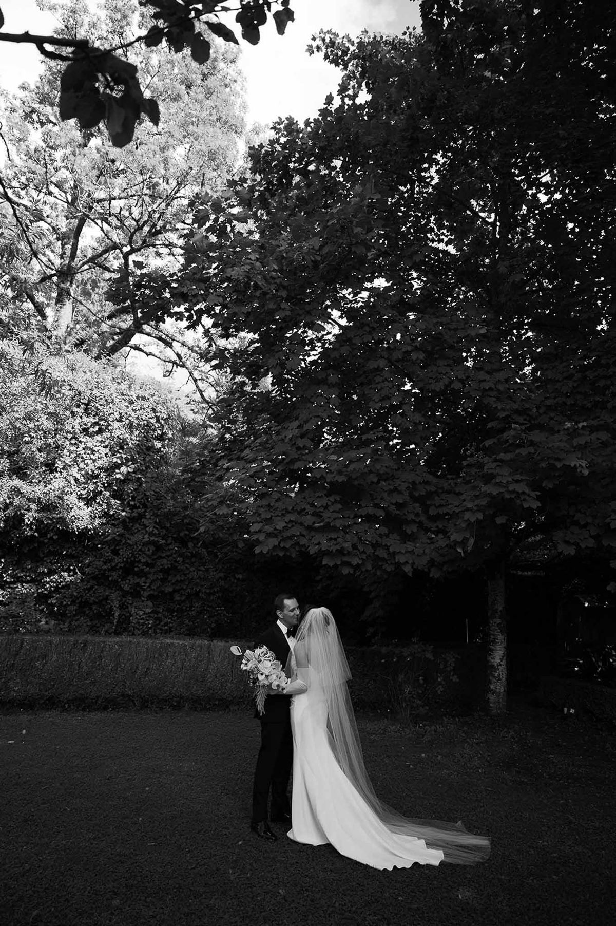 Couple embracing under tree in garden at Abbaye de Talloires