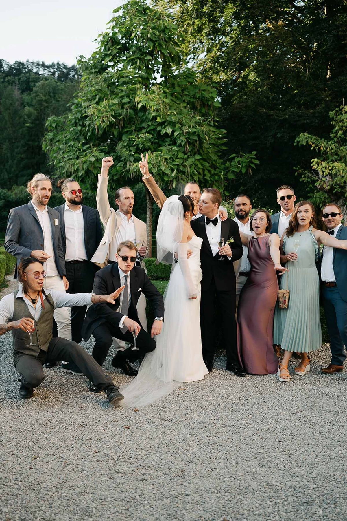 Couple kissing with cheering guests at ceremony at Abbaye de Talloires