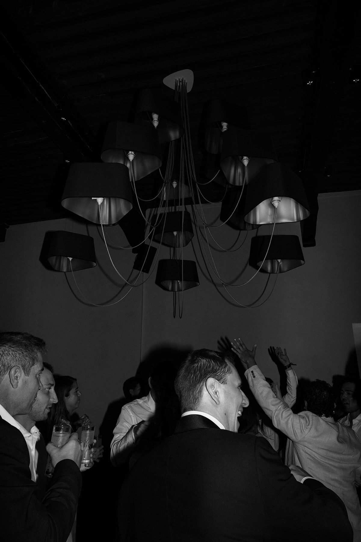Guests dance under a sculptural chandelier in black and white at Abbaye de Talloires