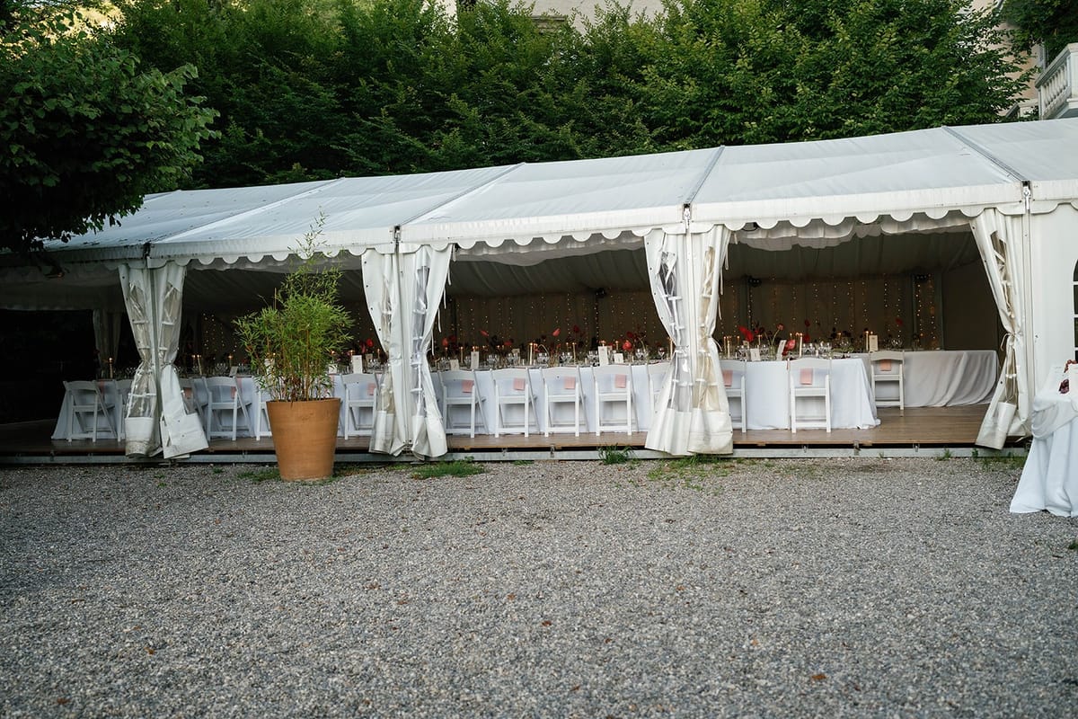 Open sided marquee set with long tables before service at Abbaye de Talloires