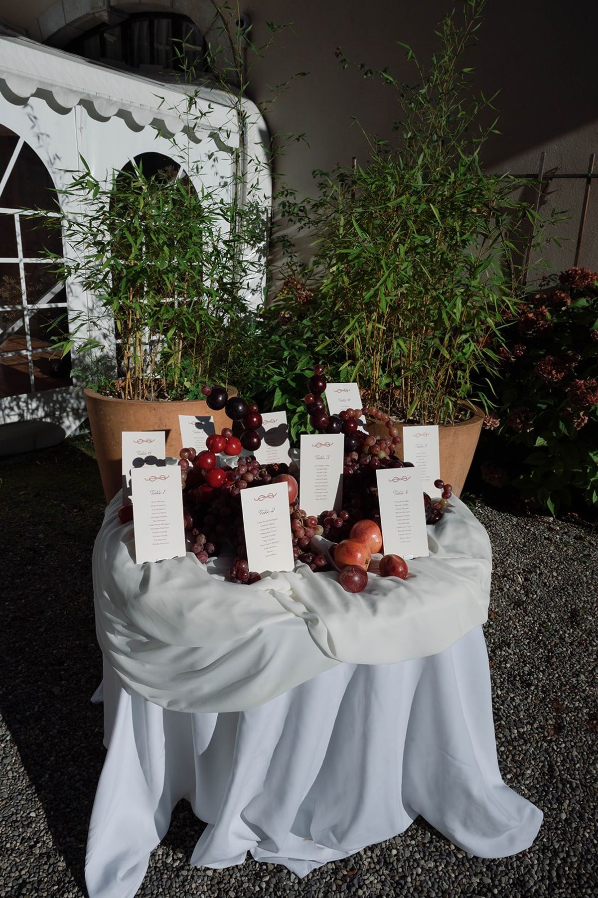 Seating cards arranged among grape clusters and bamboo planters at Abbaye de Talloires