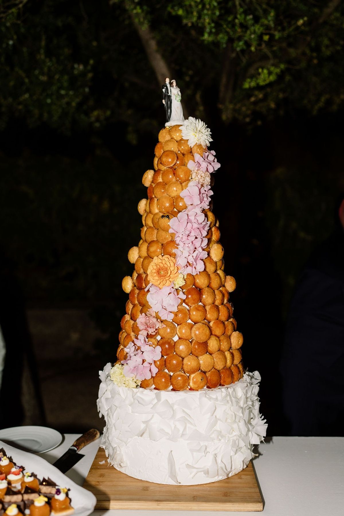 Croquembouche tower with blush hydrangea cascade and vintage couple cake topper