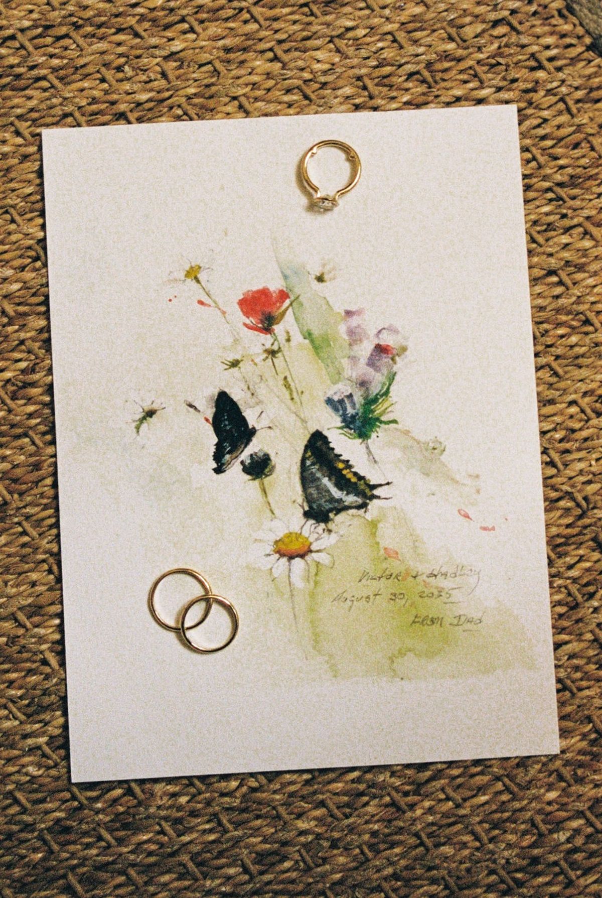 Watercolour invitation suite with poppies butterflies and rings on woven seagrass