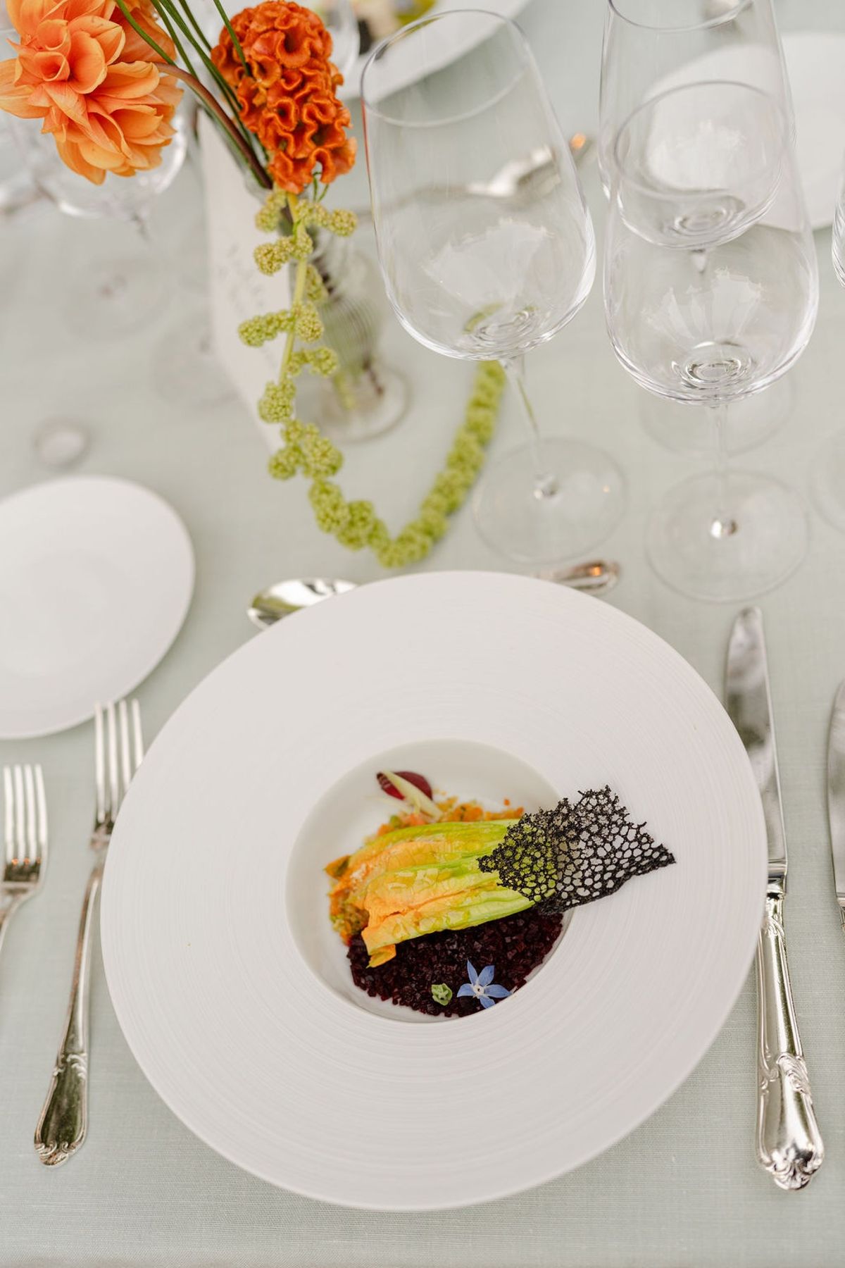 Overhead plated course with squash blossom courgette and black tuile beside dahlia