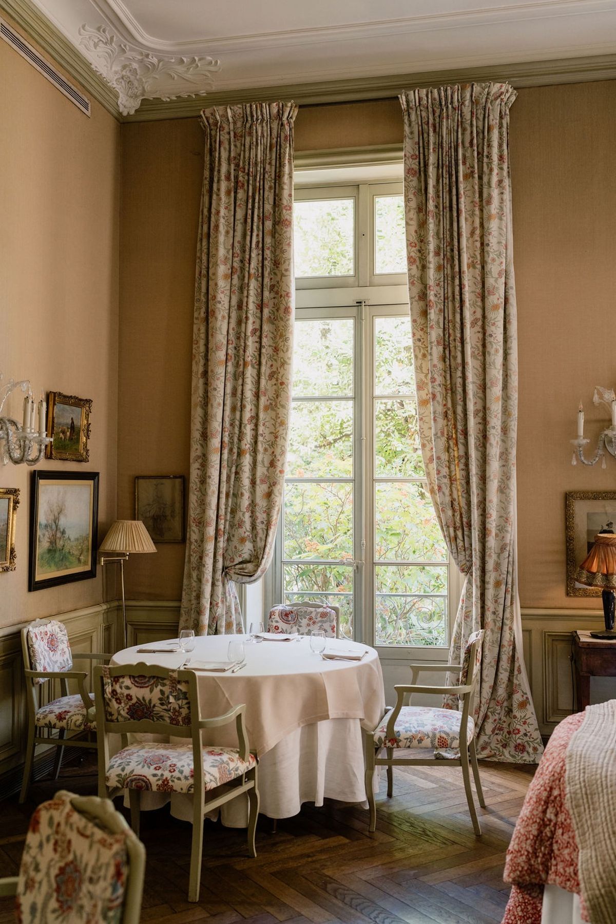 Chateau interior with floral curtains tall French window antique round table