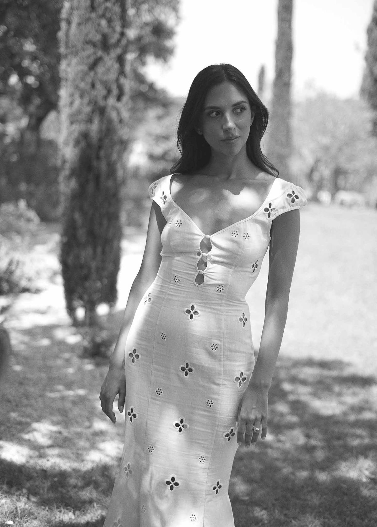 Black and white portrait of bride in broderie anglaise midi dress in dappled garden light