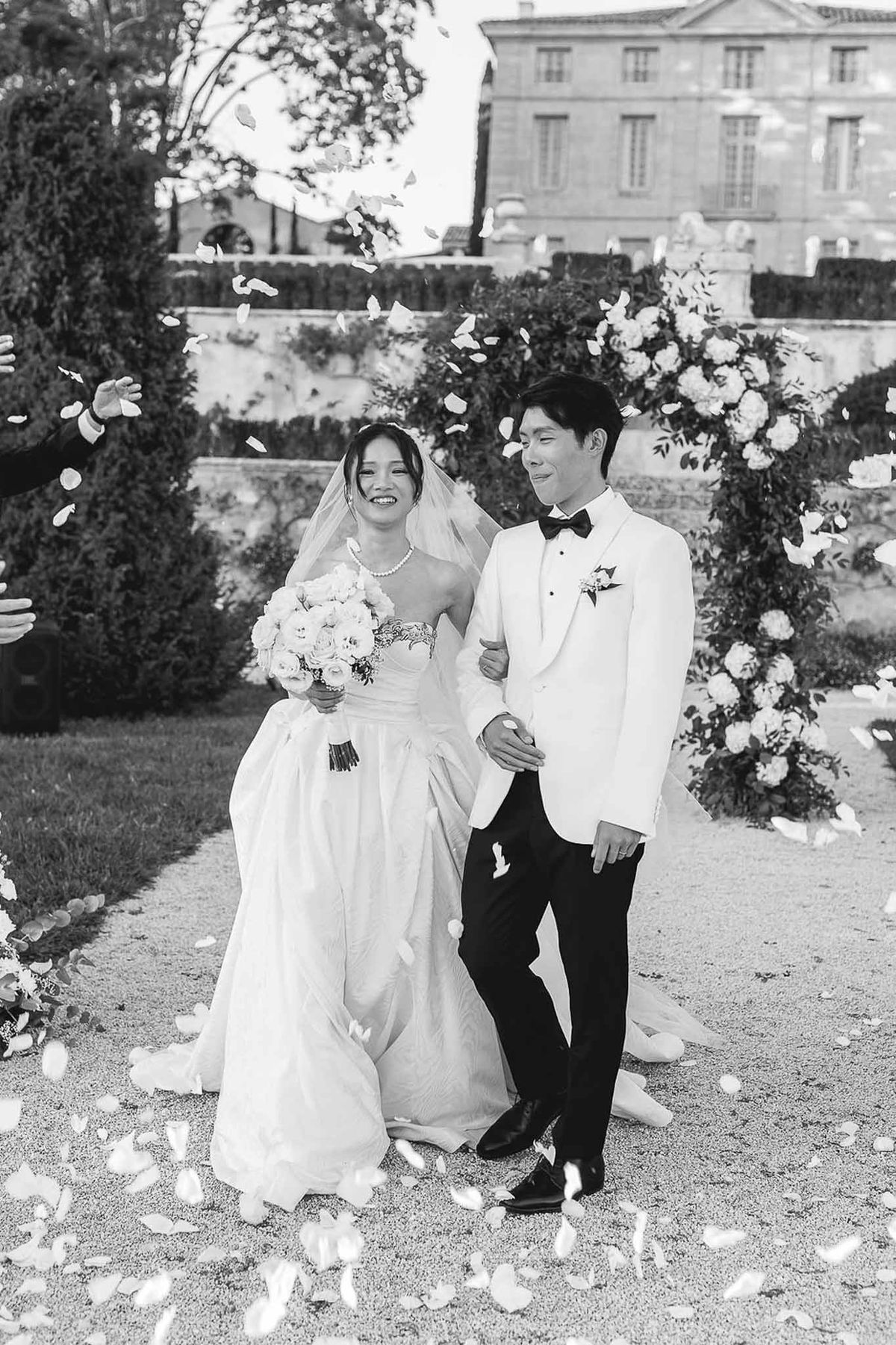 Bride and groom walking through petal toss after ceremony at Château de la Gaude