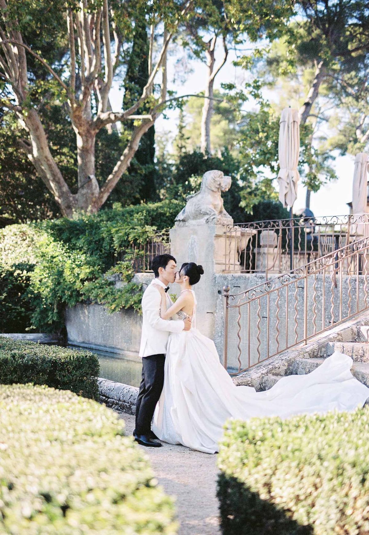 Bride and groom embracing during first look on garden steps at Château de la Gaude