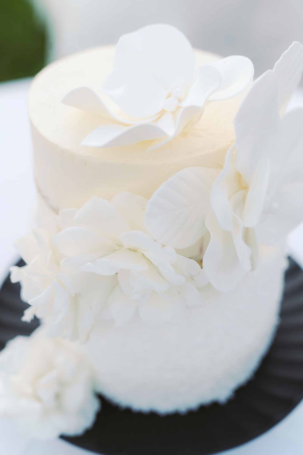 Close-up of white wedding cake decorated with sugar flowers at Château de la Gaude
