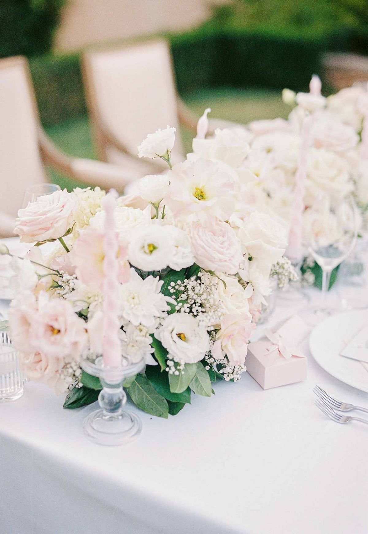 Reception table with blush rose centrepieces and pink candles at Château de la Gaude