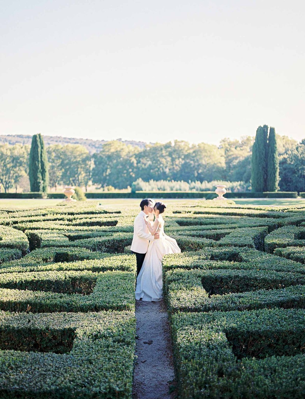 Couple embracing in maze garden at golden hour at Château de la Gaude