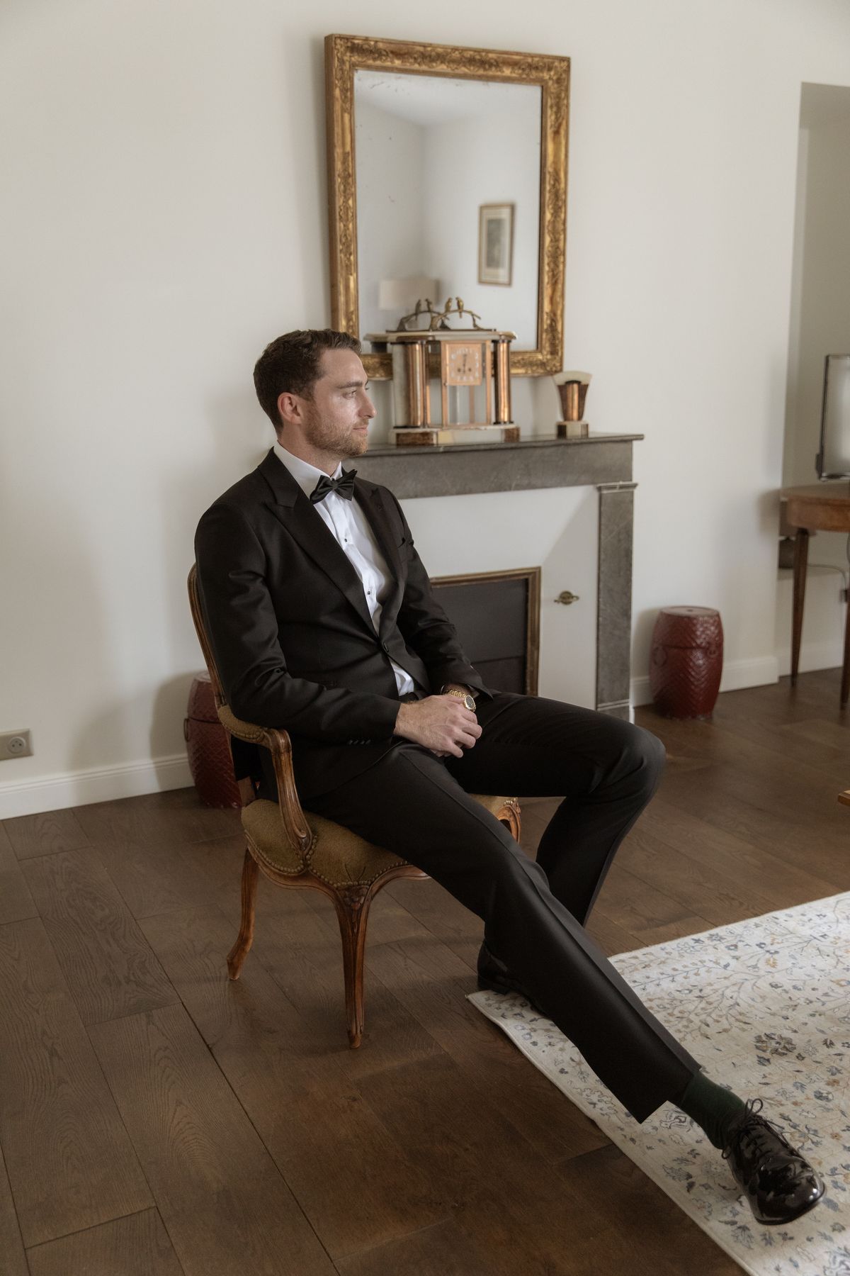 Groom in black tie seated before the ceremony at Chateau Gassies, Nouvelle-Aquitaine