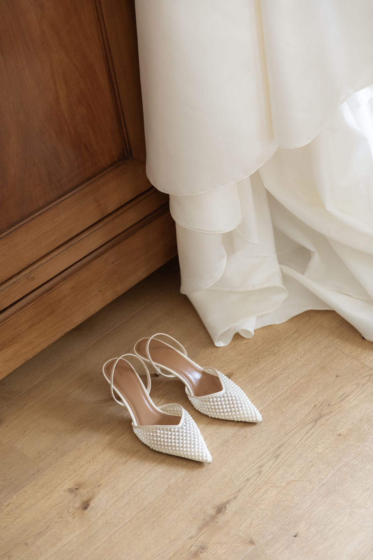 Pearl bridal heels beside the wedding dress at Chateau Gassies, Nouvelle-Aquitaine