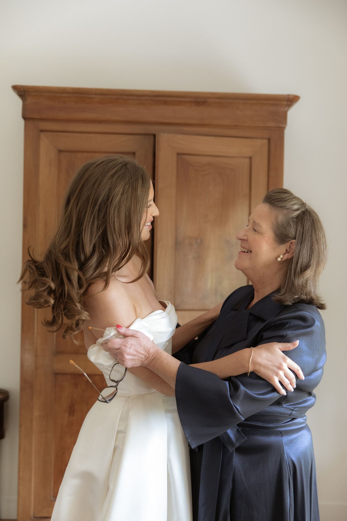 Bride and mother embracing during prep at Chateau Gassies, Nouvelle-Aquitaine