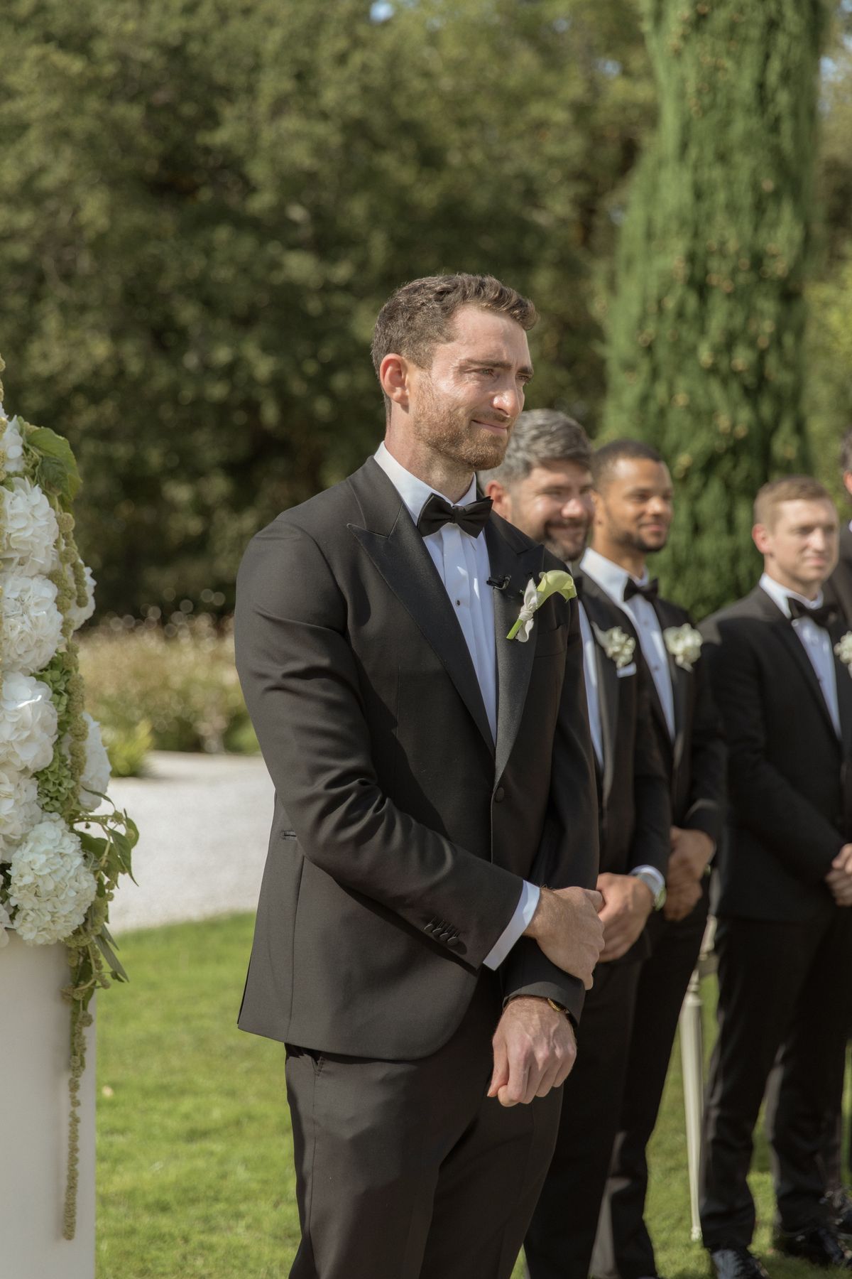 Groom watching the bride at the ceremony altar at Chateau Gassies, Nouvelle-Aquitaine