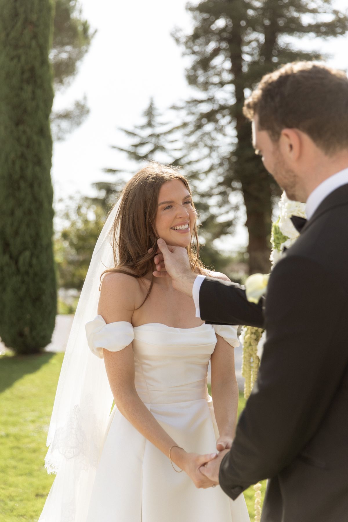 Bride smiling at the groom during the ceremony at Chateau Gassies, Nouvelle-Aquitaine