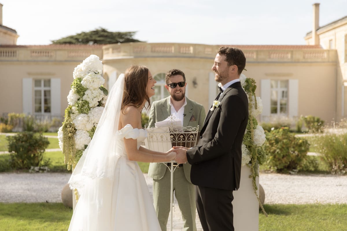 Bride and groom at the altar with floral pillars at Chateau Gassies, Nouvelle-Aquitaine