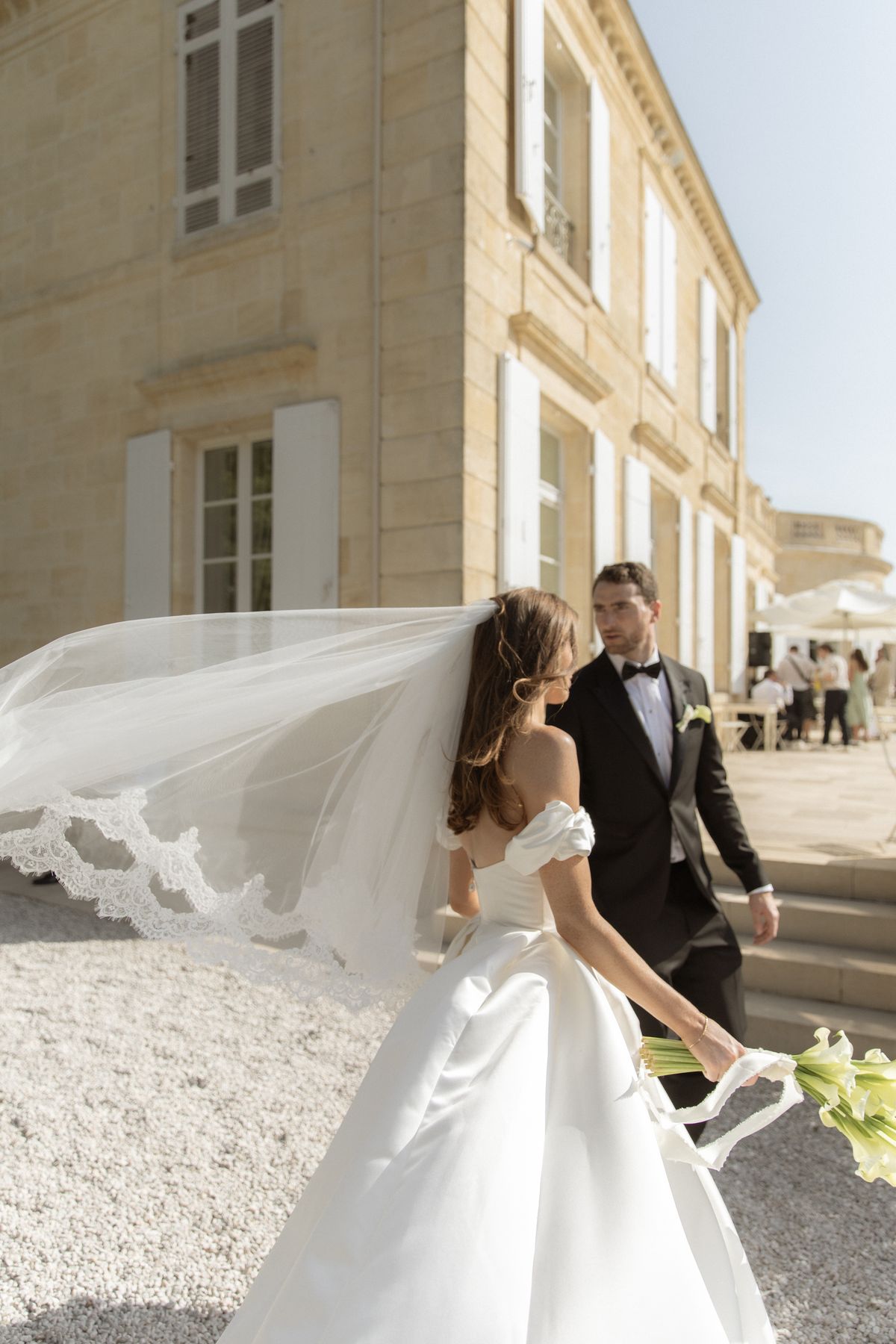 Bride and groom portrait with veil in motion at Chateau Gassies, Nouvelle-Aquitaine