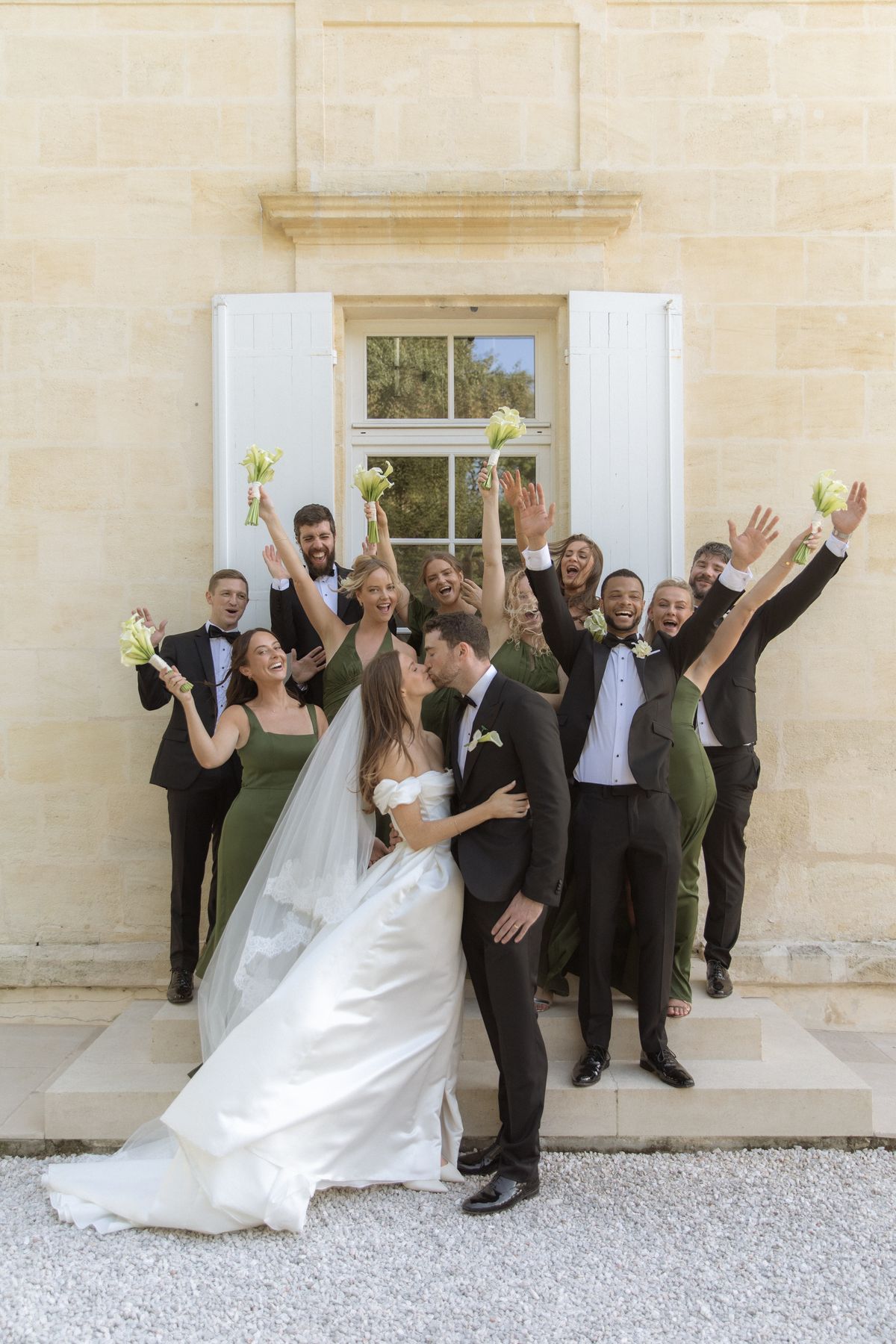 Bridal party celebrating the couple kiss at Chateau Gassies, Nouvelle-Aquitaine