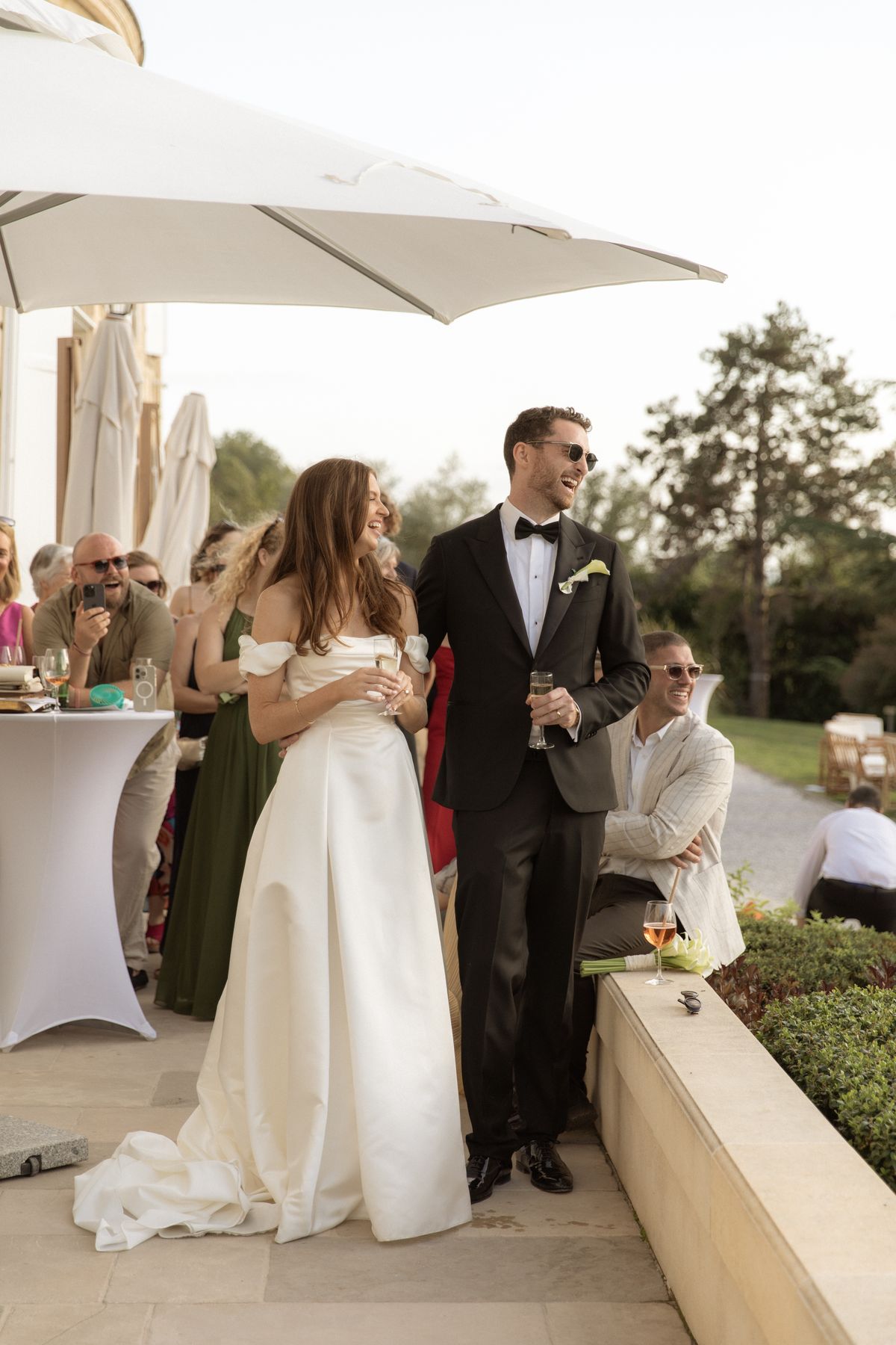 Bride and groom on the terrace during cocktail hour at Chateau Gassies, Nouvelle-Aquitaine