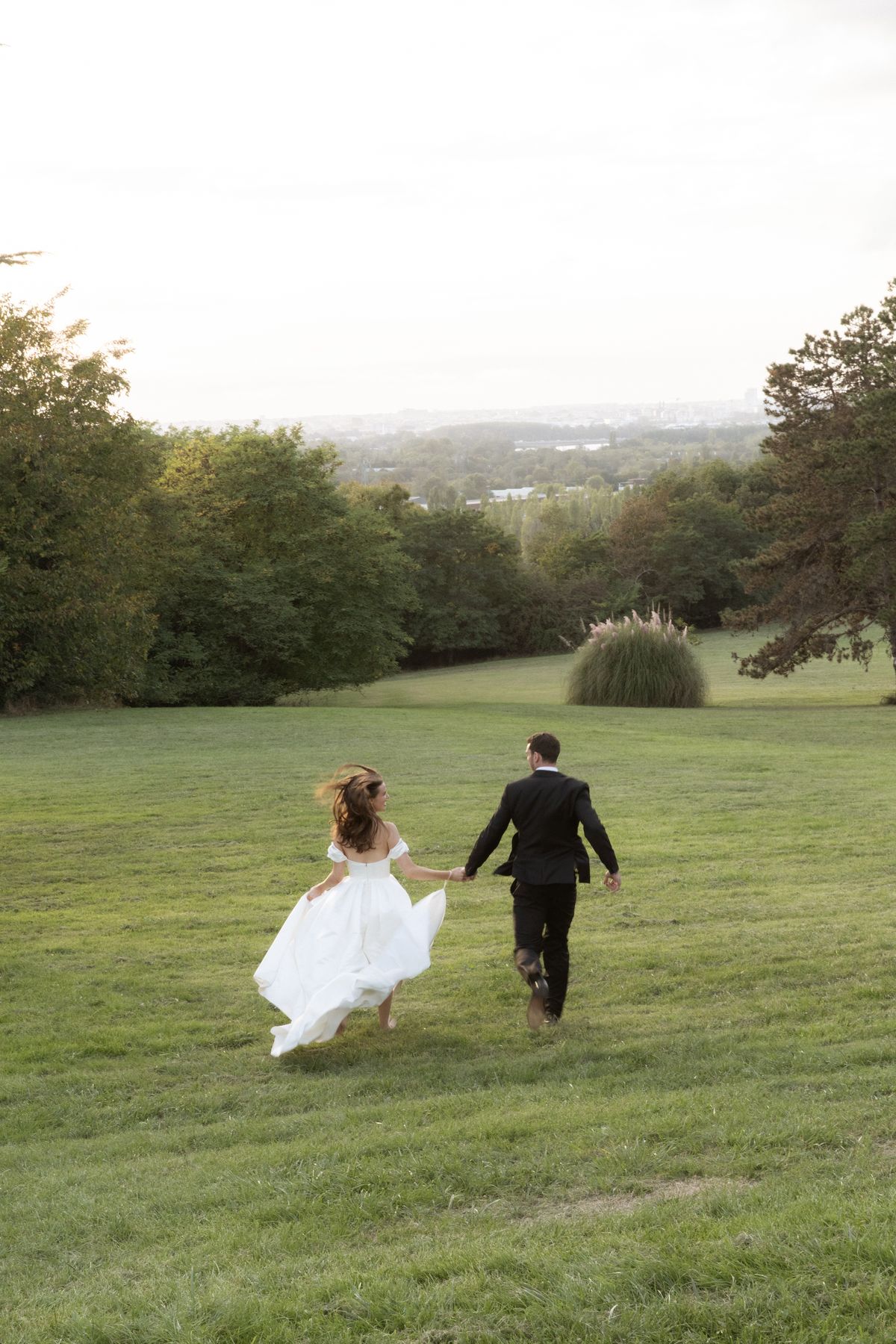 Bride and groom running through a meadow near Bordeaux, Nouvelle-Aquitaine