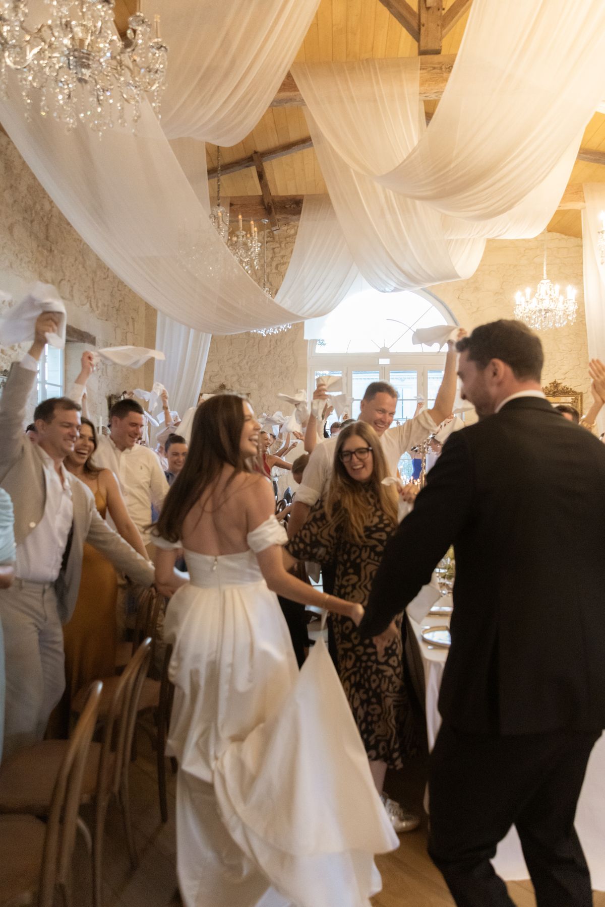 Couple grand entrance into the draped reception at Chateau Gassies, Nouvelle-Aquitaine