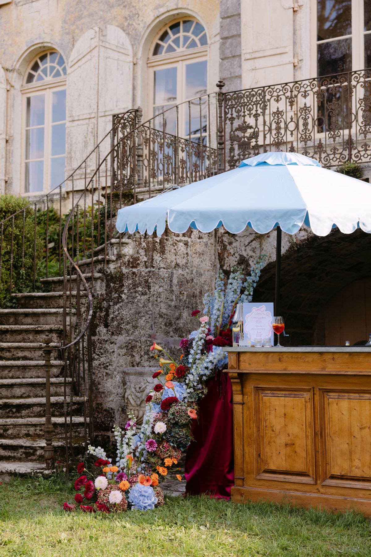 Poolside welcome drinks under sky-blue parasols in the gardens of Domaine de Perrotin for Rooa and Mark's wedding weekend