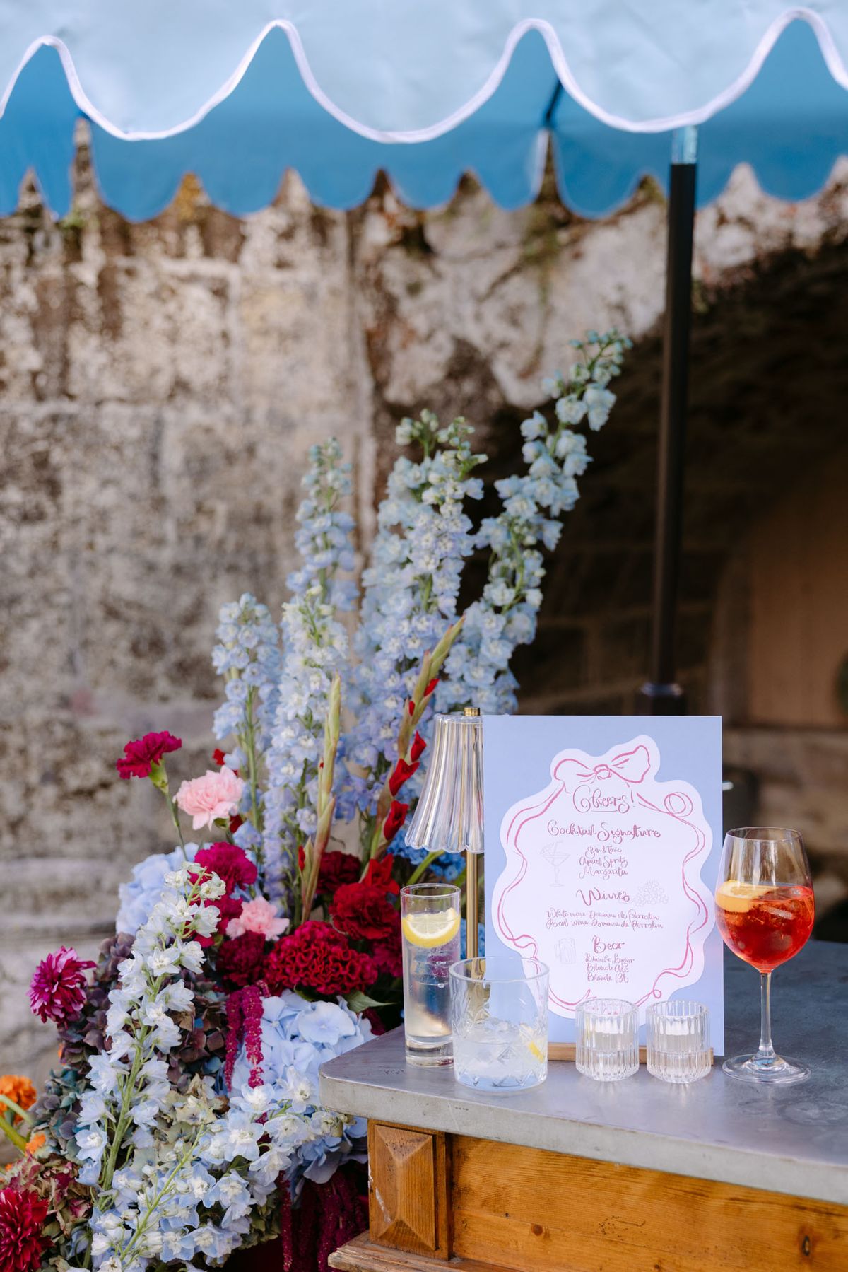 Colourful wedding details at Domaine de Perrotin in shades of fuchsia, raspberry, sky blue and orange, from the florals and tablescapes of Rooa and Mark's celebration