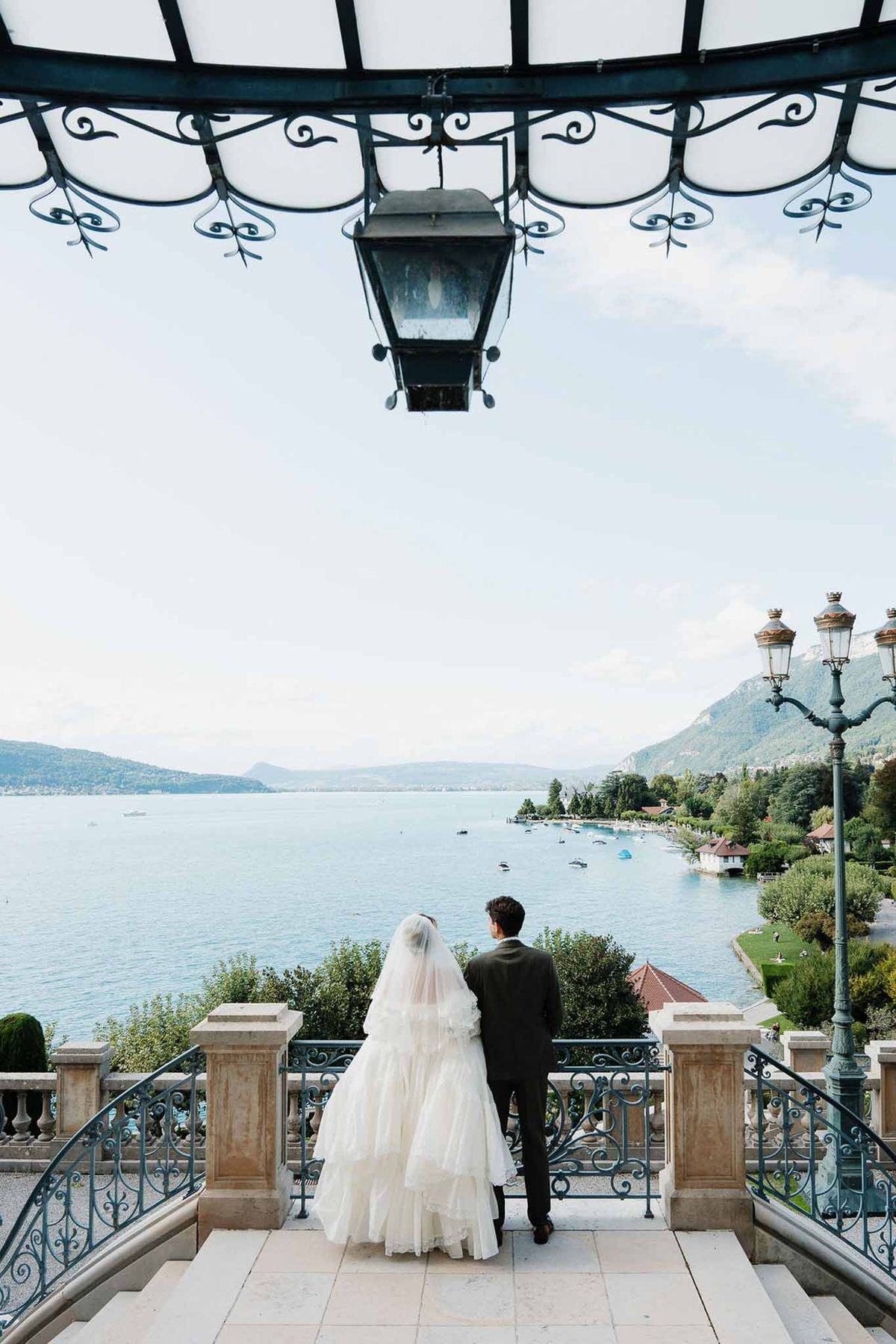 Couple from behind overlooking Lake Annecy panorama from hotel canopy at Palace de Menthon
