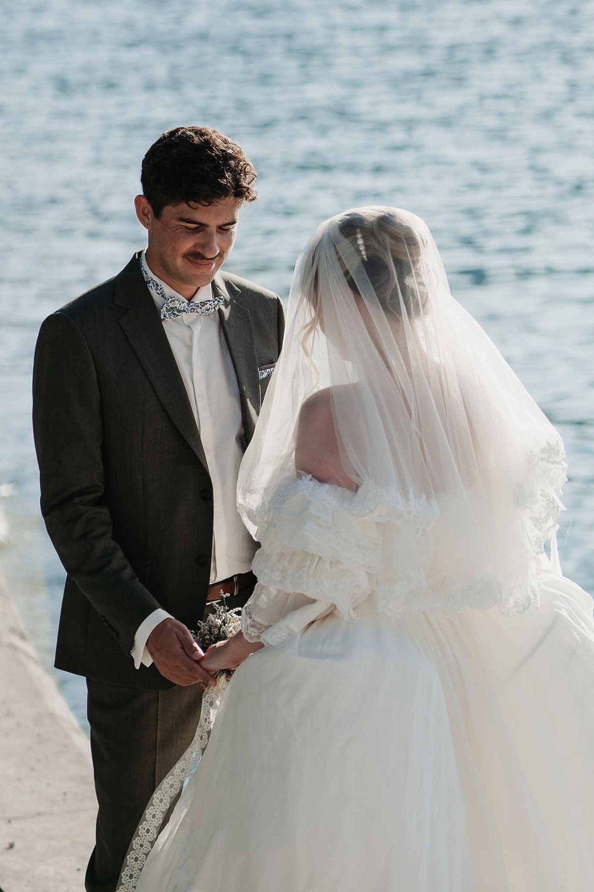 Couple holding hands on lakeside promenade at Palace de Menthon Annecy