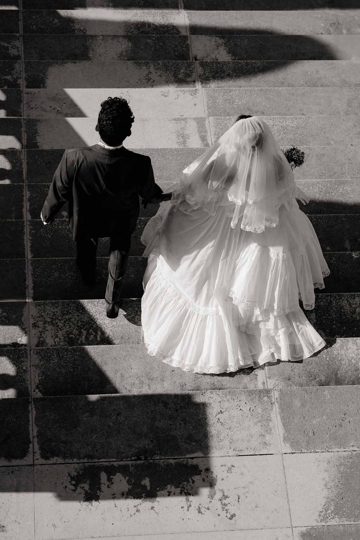 Couple descending grand staircase from above in black and white at Palace de Menthon