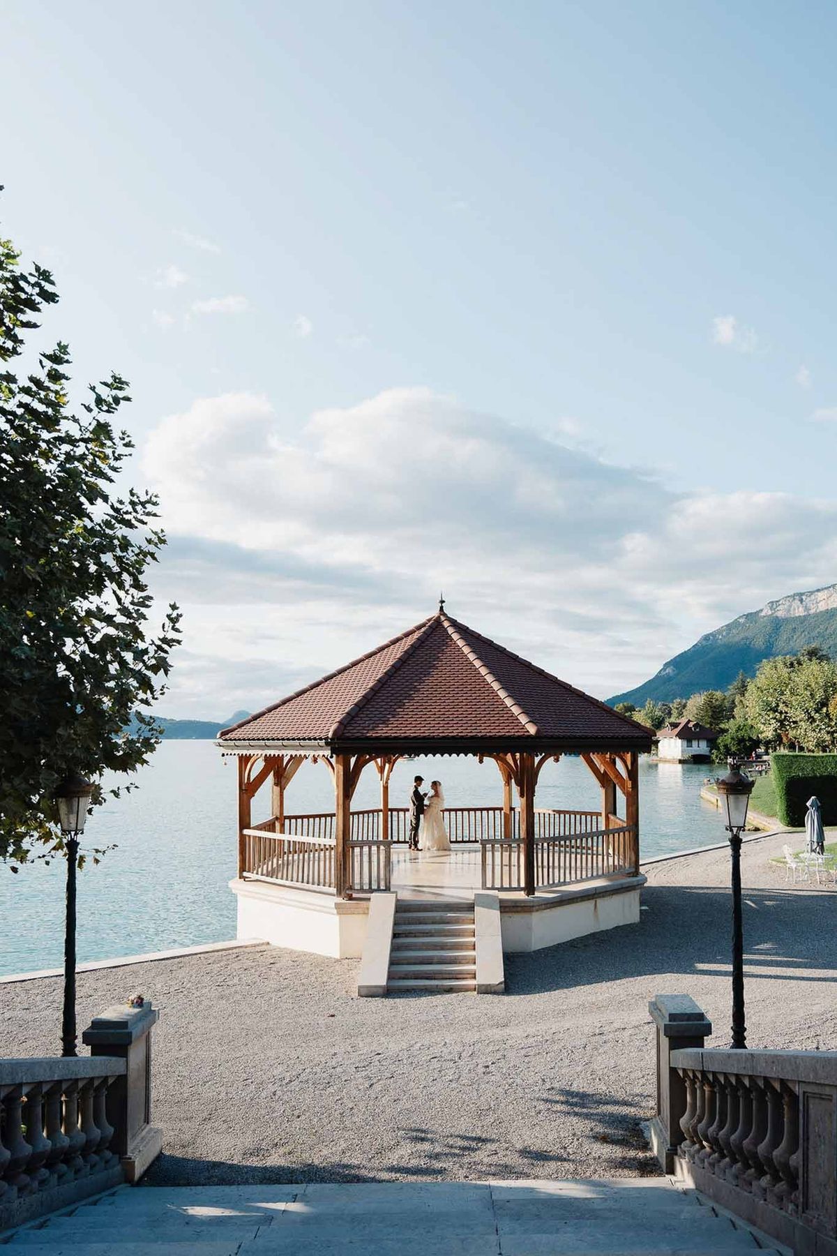 Couple in wooden lakeside pavilion with Lake Annecy panorama at Palace de Menthon