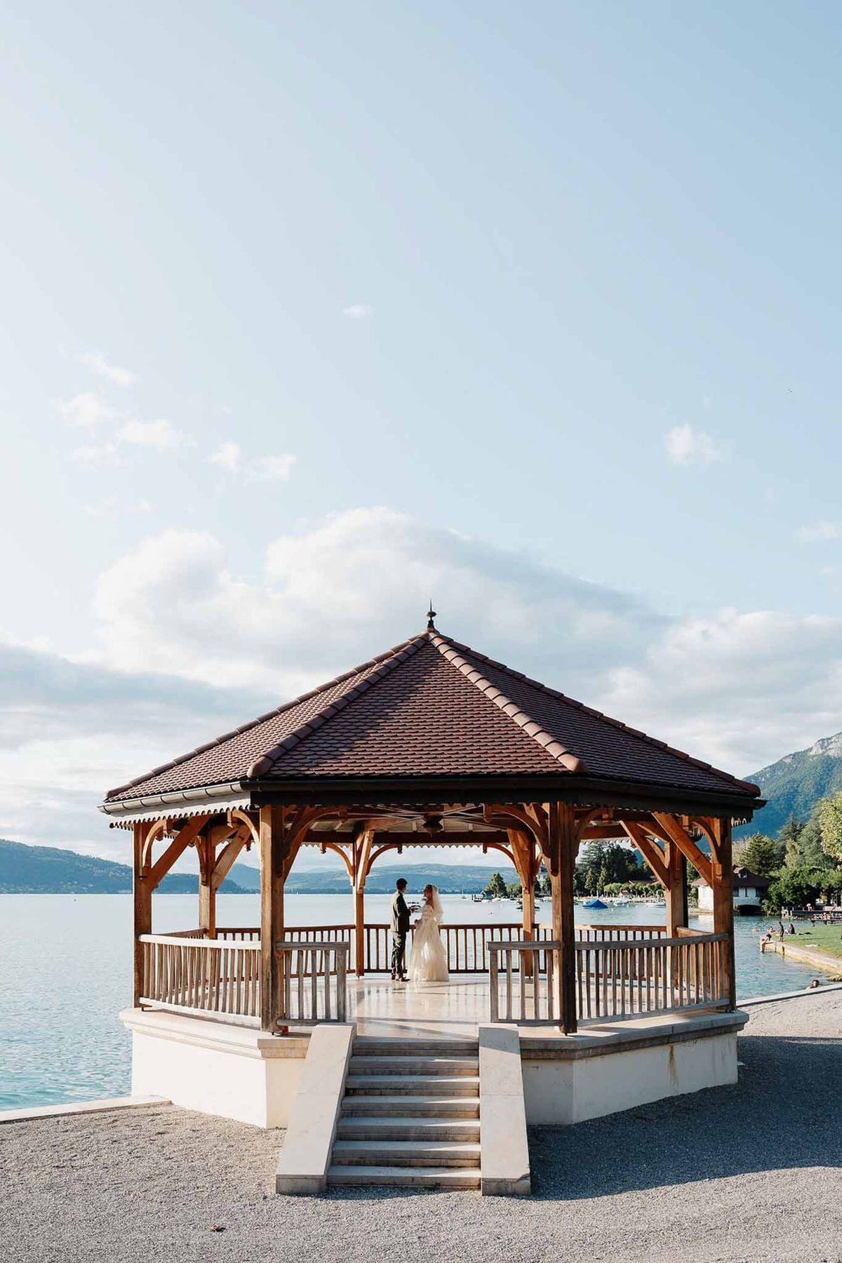 Wooden pavilion over Lake Annecy with couple silhouette at Palace de Menthon