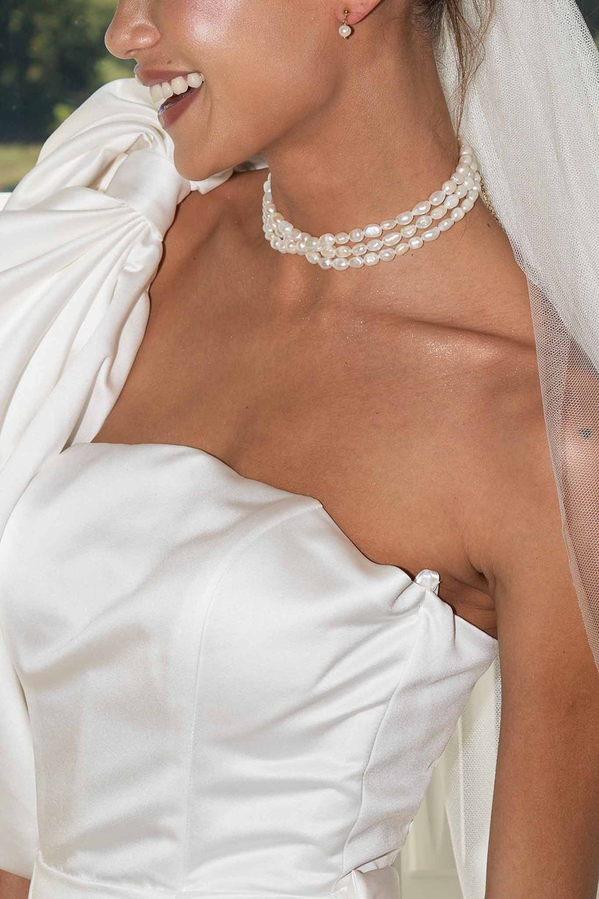 Bride in sculptural gown with pearl necklace at Château du Griffon