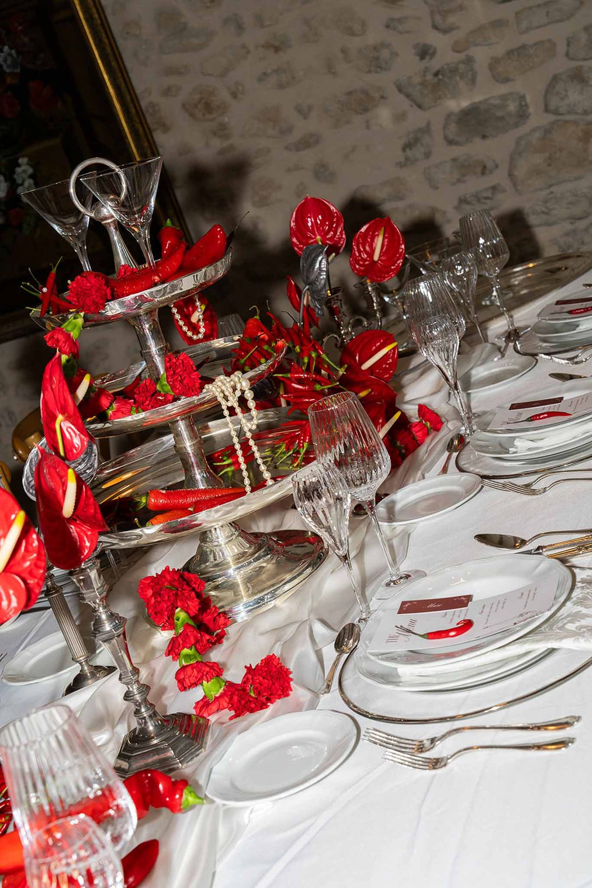 Red chilli and flower centrepiece with silver trays at reception