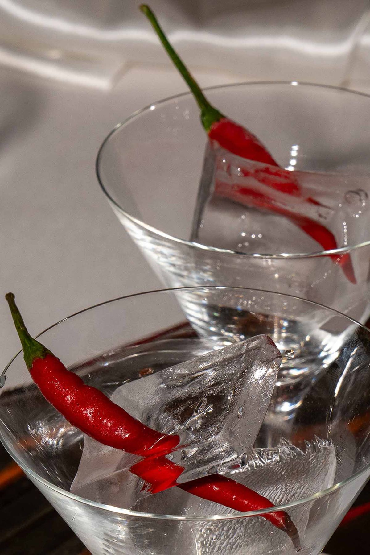 Champagne glass with ice cubes and red chillies
