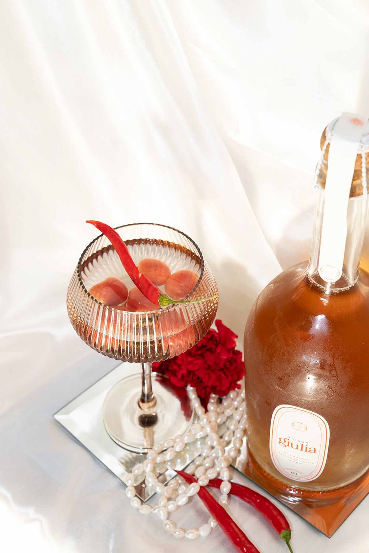 Champagne glass cocktail drink with chilli garnish