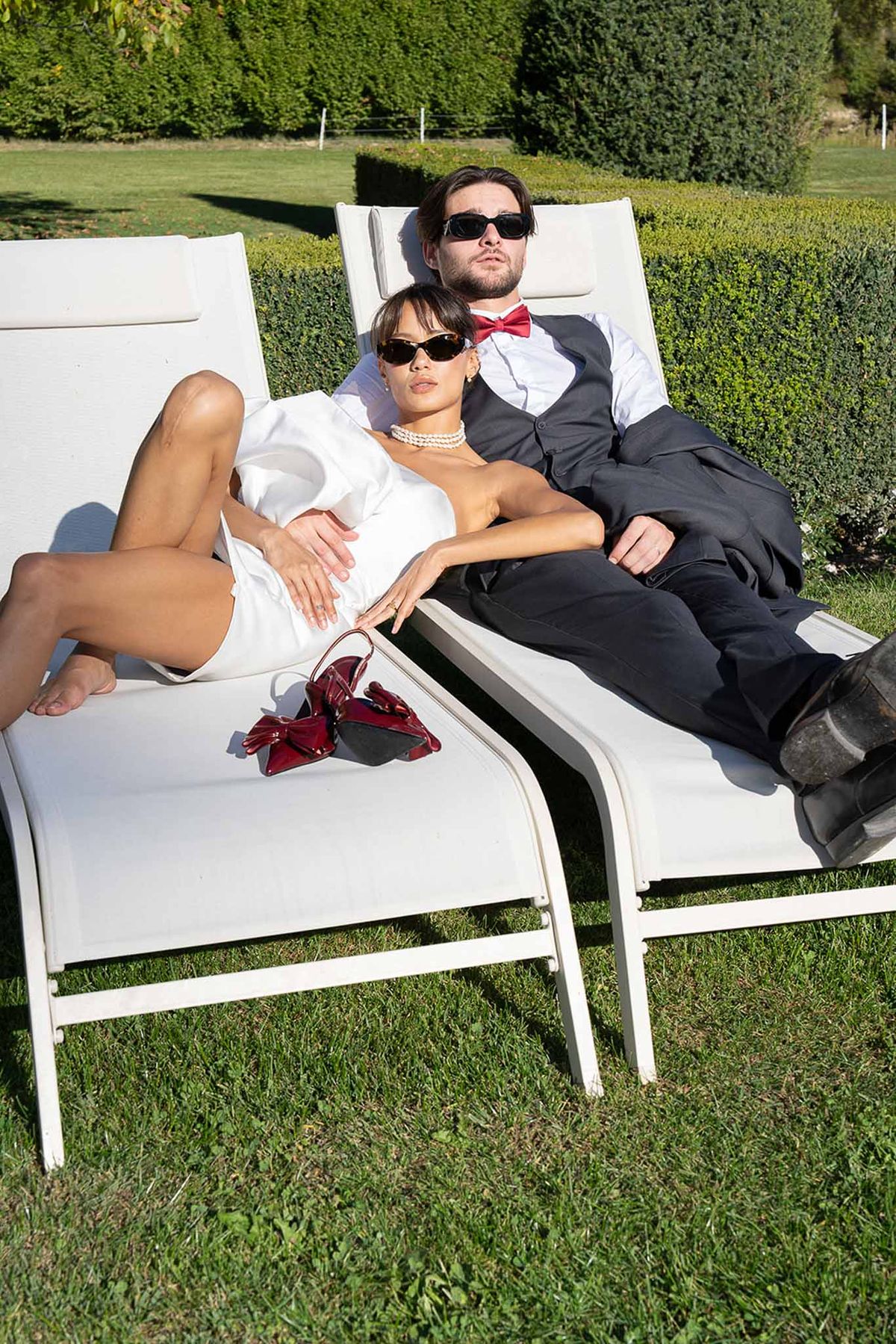 Bride and groom sitting on lounge chair during golden hour at Château du Griffon