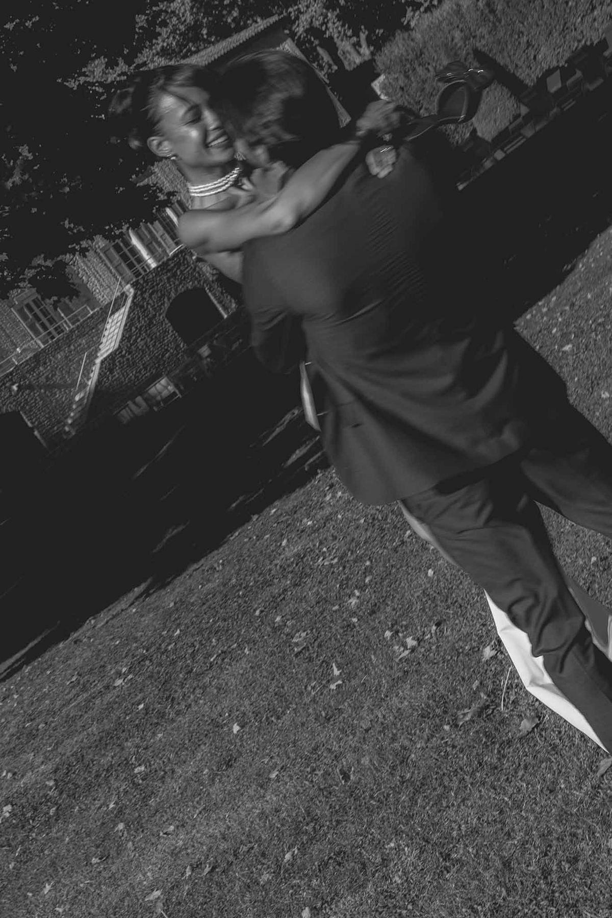 Groom carrying and kissing bride in garden
