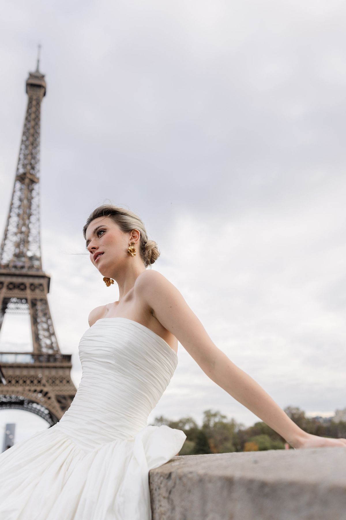 Bride in a strapless gown with the Eiffel Tower behind her