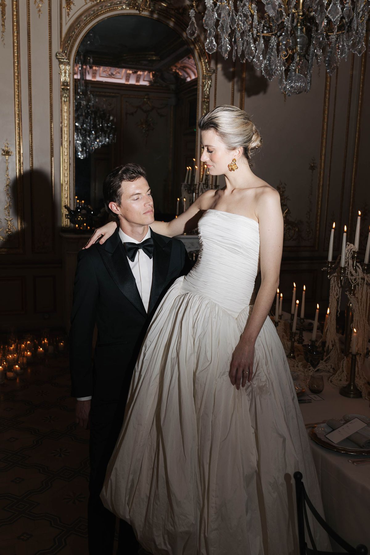 Groom kissing the bride's shoulder in the candlelit reception