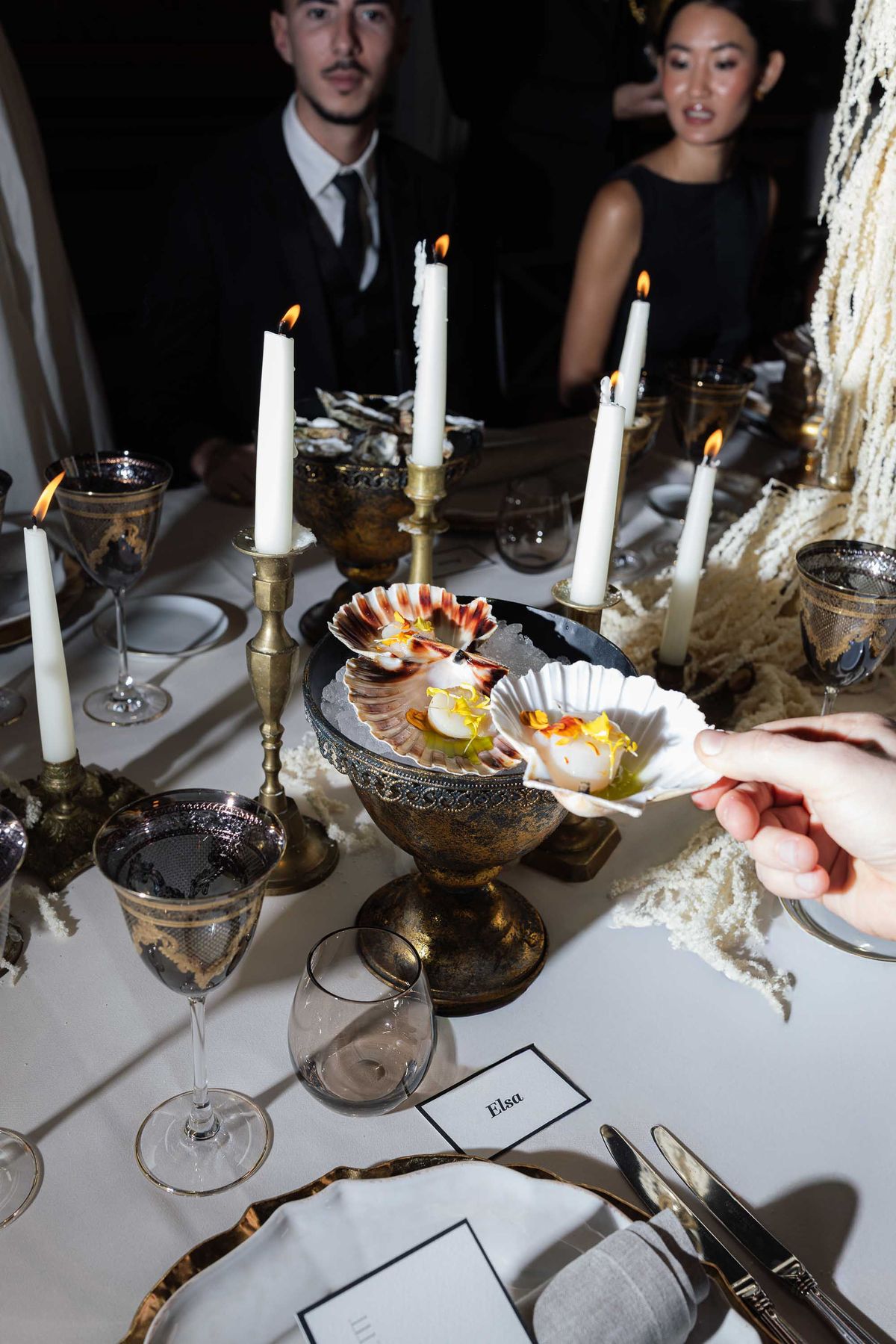 Scallops served on silver amid candlelight