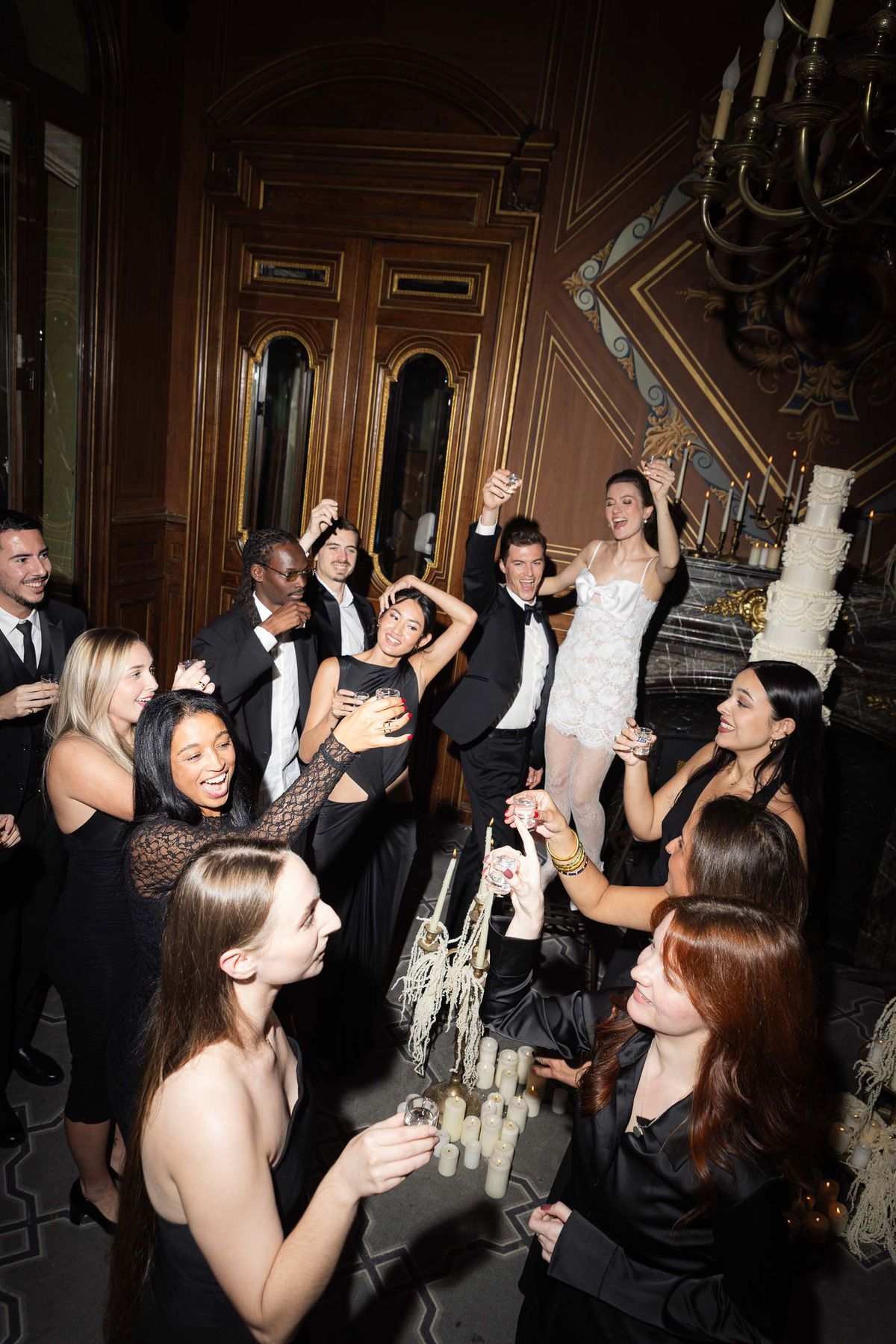 Guests celebrating around the couple at the candlelit Paris reception