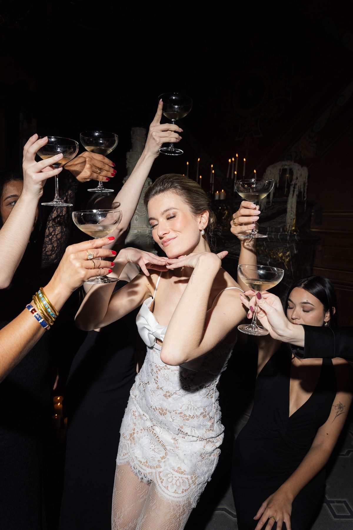 Guests raising champagne coupes at the candlelit celebration