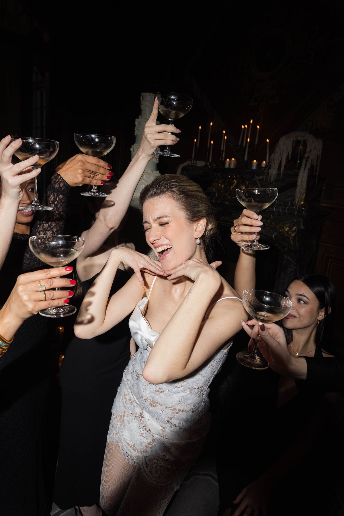 Bride laughing with guests over champagne at the reception