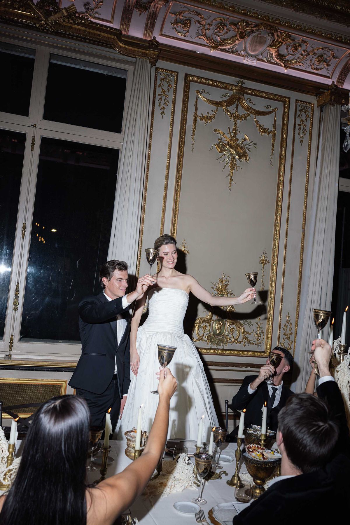 Couple and guests toasting during the evening celebration